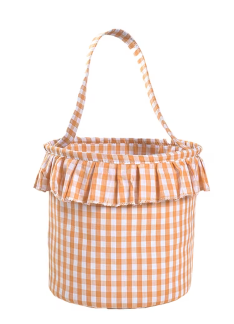 A fabric storage basket with a peach and white gingham check pattern, featuring a ruffled trim around the rim and a matching fabric handle, shown against a plain white background.